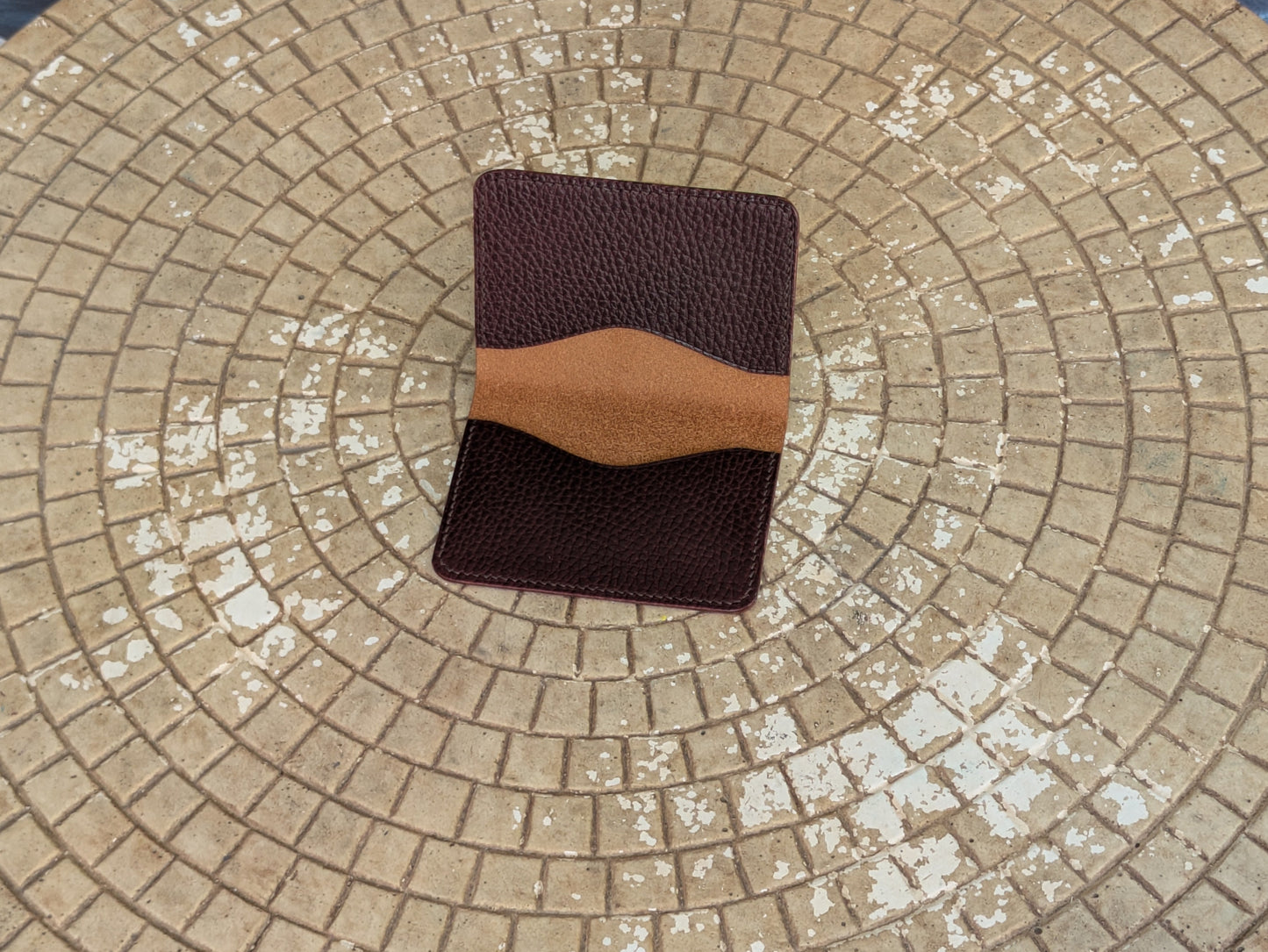 A minimal two-pocket card wallet in deep purple brown and chestnut coloring.